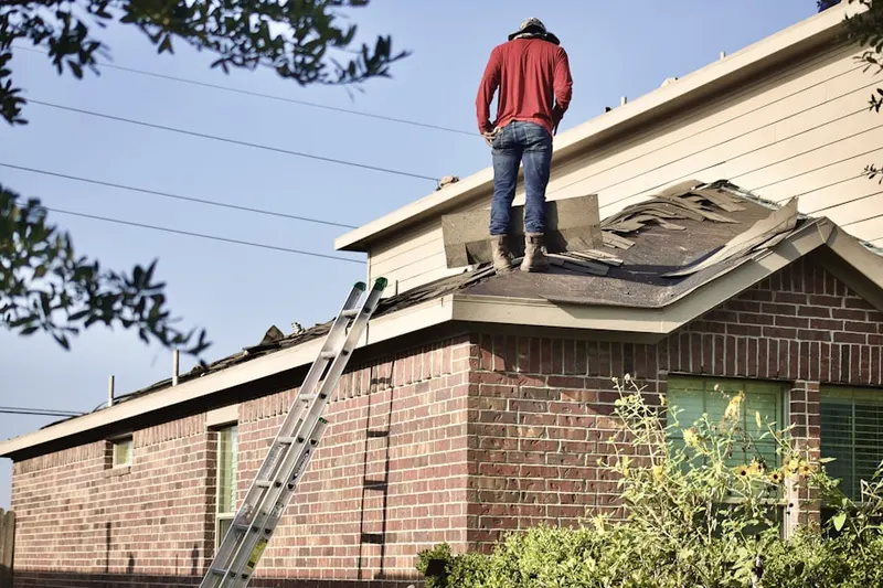 Professional roofer working on a residential roof in Plainville